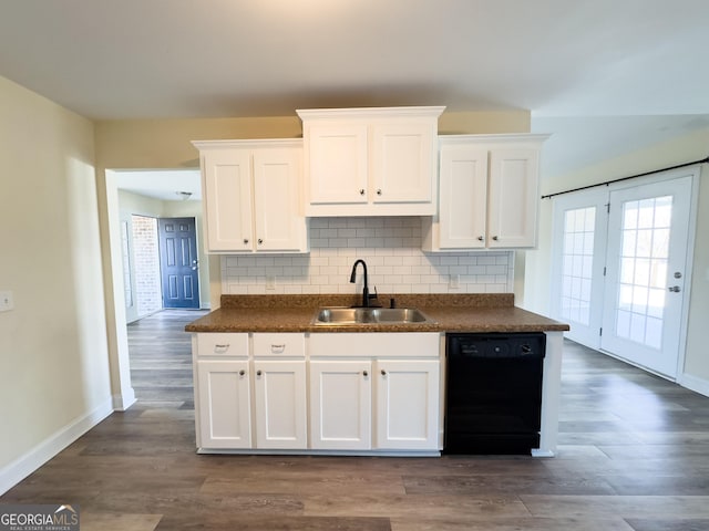 kitchen with black dishwasher, tasteful backsplash, dark countertops, white cabinetry, and a sink