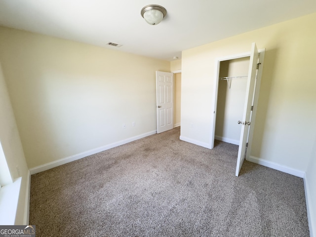 unfurnished bedroom featuring a closet, carpet flooring, visible vents, and baseboards