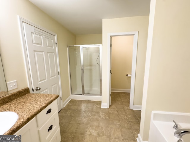 bathroom featuring a stall shower, baseboards, and vanity