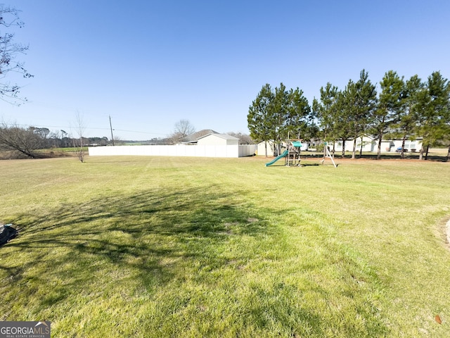 view of yard with playground community and fence