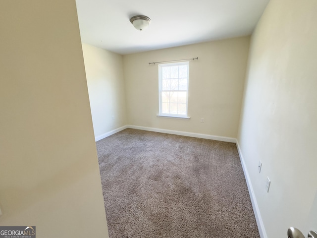 spare room featuring carpet and baseboards