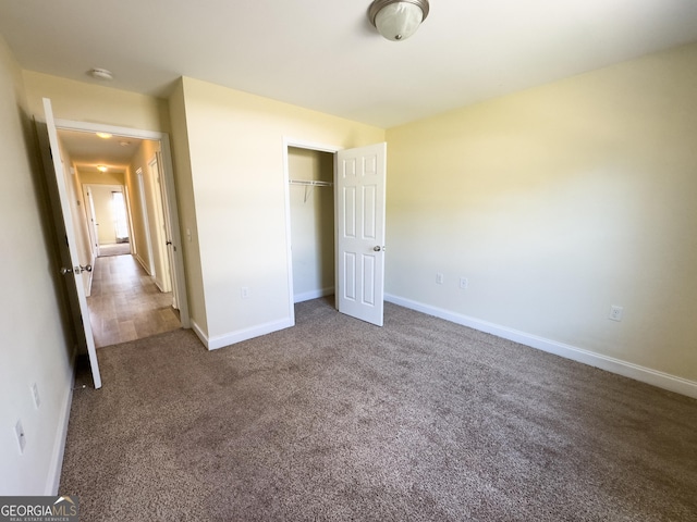 unfurnished bedroom featuring carpet floors, a closet, and baseboards