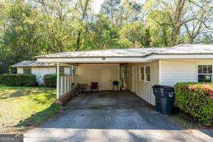 exterior space with driveway, an attached carport, and a front yard