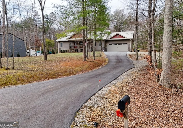 ranch-style house featuring a garage and aphalt driveway