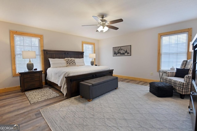 bedroom with ceiling fan, baseboards, and wood finished floors