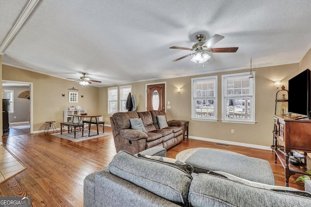 living area with visible vents, crown molding, a textured ceiling, and hardwood / wood-style flooring