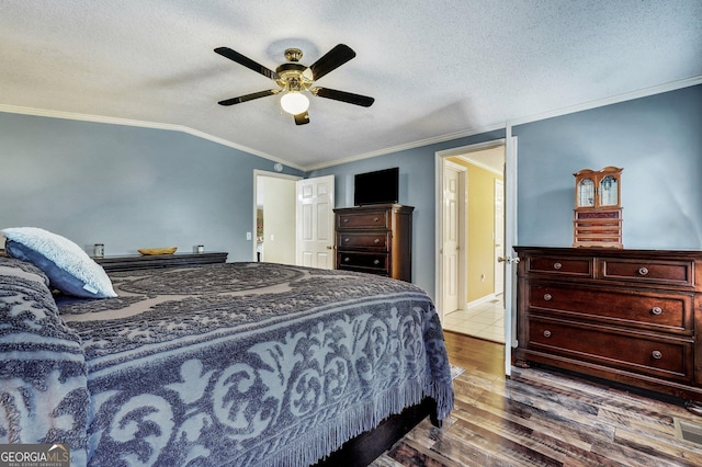 bedroom with crown molding, ceiling fan, vaulted ceiling, a textured ceiling, and wood finished floors