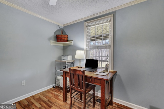 office area with a textured ceiling, ornamental molding, wood finished floors, and baseboards