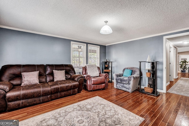 living area with ornamental molding, a textured ceiling, baseboards, and wood finished floors