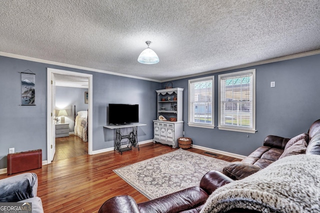 living room featuring crown molding, a textured ceiling, baseboards, and wood finished floors