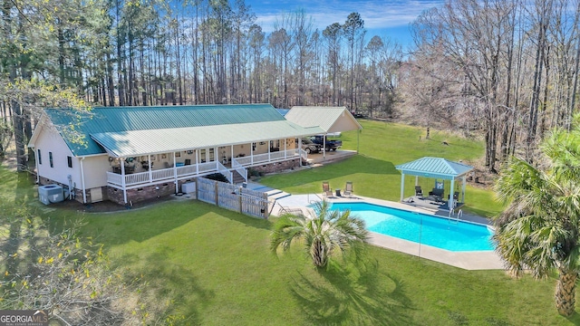 back of property featuring metal roof, a patio, cooling unit, a gazebo, and a lawn