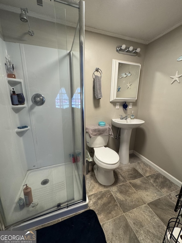 bathroom featuring toilet, a shower stall, and baseboards