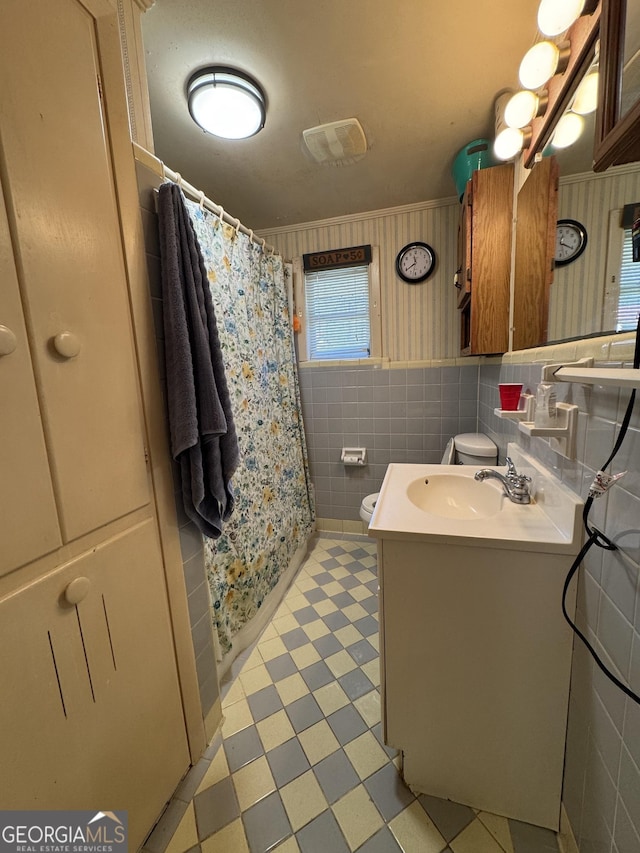 full bath featuring tile walls, toilet, vanity, a shower with curtain, and tile patterned floors