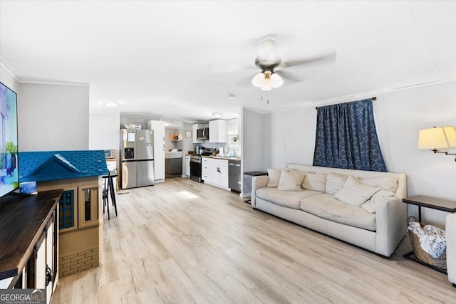 living room featuring ornamental molding, light wood-type flooring, and a ceiling fan