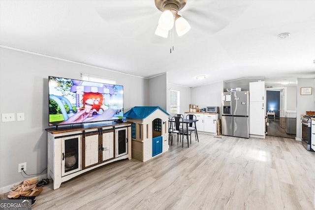 interior space featuring vaulted ceiling, light wood-type flooring, plenty of natural light, and a ceiling fan