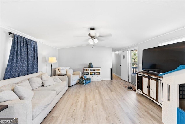 living room featuring ceiling fan, wood finished floors, baseboards, vaulted ceiling, and crown molding