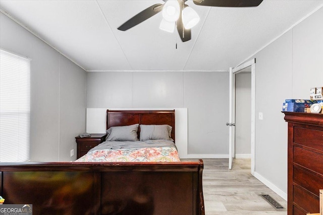 bedroom featuring ceiling fan, wood finished floors, and visible vents