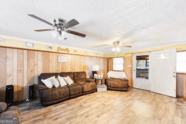 living area featuring a textured ceiling, ceiling fan, wood finished floors, and visible vents