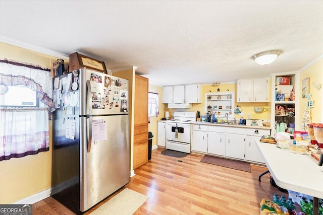 kitchen featuring light wood-style floors, light countertops, electric stove, and freestanding refrigerator