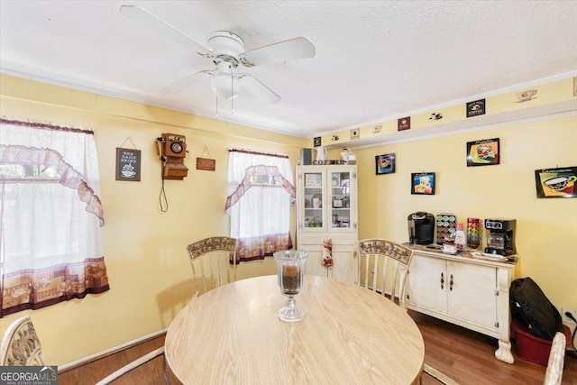 dining room featuring a textured ceiling, a ceiling fan, and dark wood-style flooring