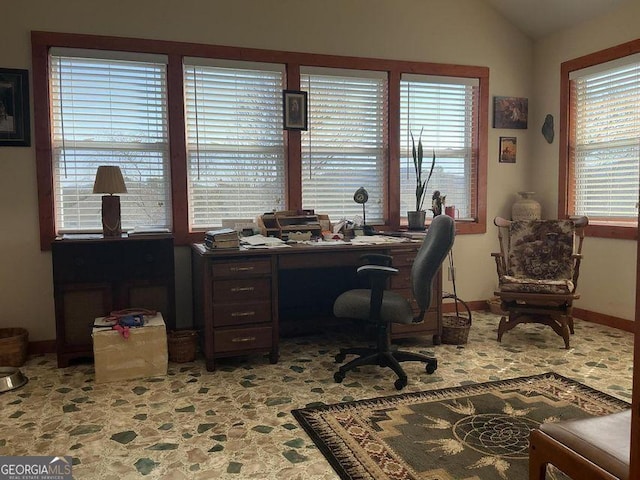 office with lofted ceiling and baseboards