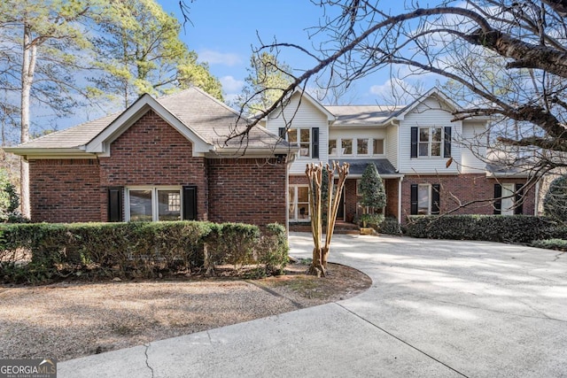 traditional home with driveway and brick siding