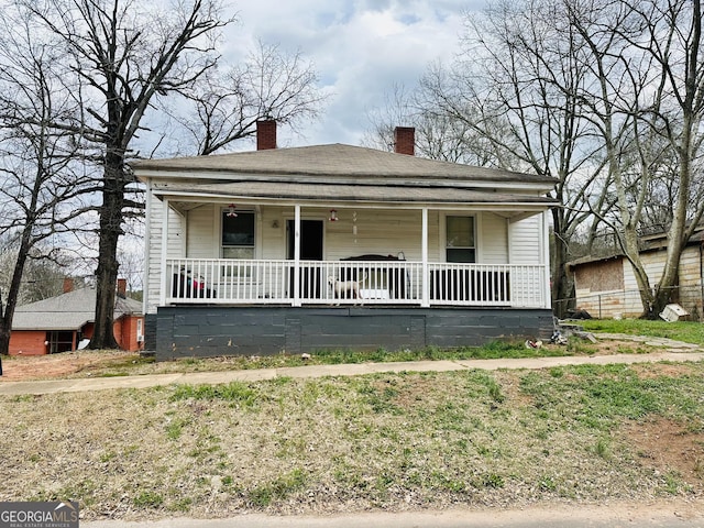 view of front of house with covered porch and a chimney