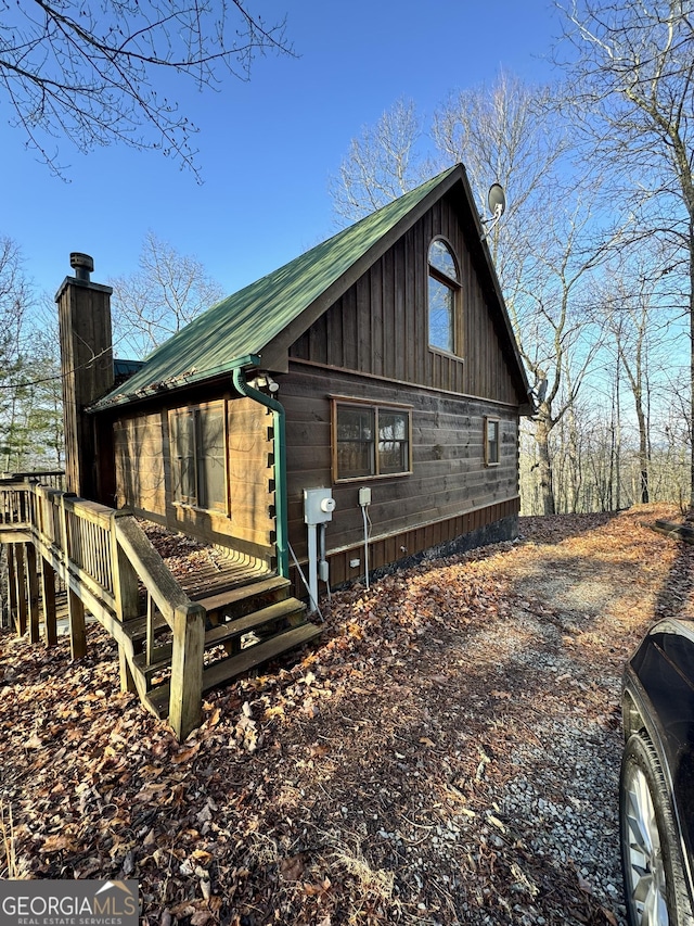 view of front of property featuring a chimney and metal roof