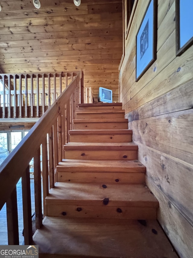 staircase featuring wooden walls