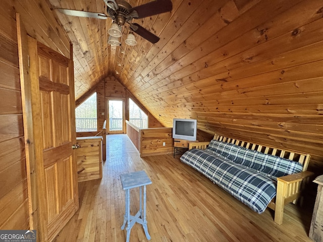 bedroom with vaulted ceiling, wooden ceiling, wood-type flooring, and wooden walls