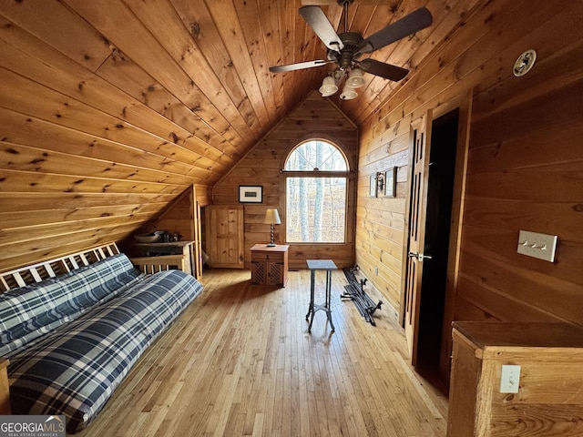 unfurnished bedroom featuring light wood-type flooring, wood walls, wood ceiling, and lofted ceiling