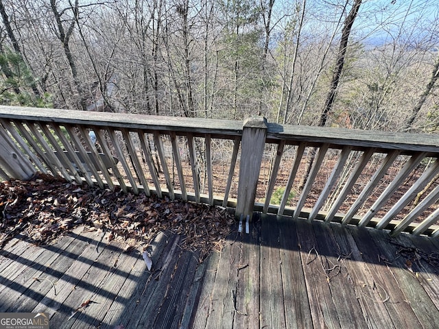 wooden terrace featuring a forest view