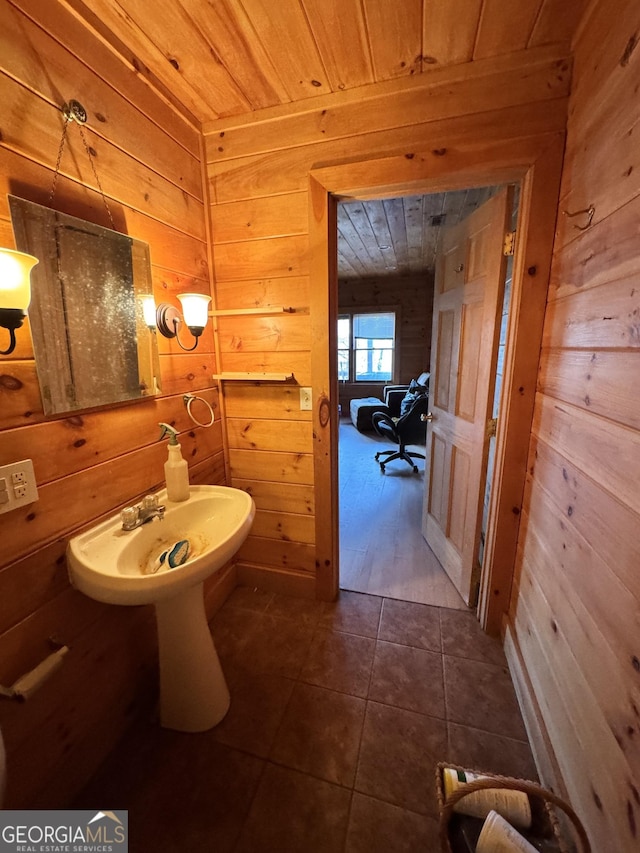 bathroom with tile patterned flooring, wooden ceiling, and wood walls