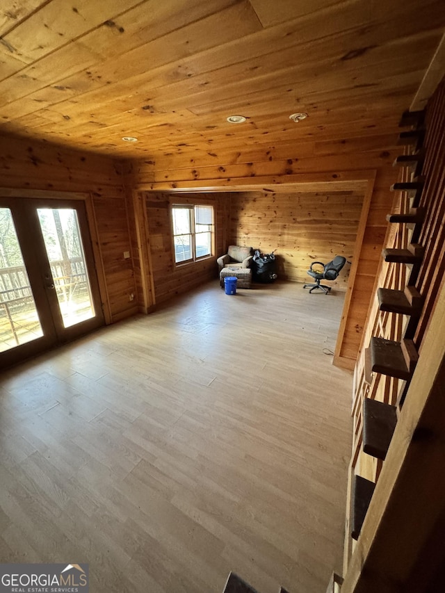 bonus room with light wood-type flooring, wooden ceiling, and wood walls