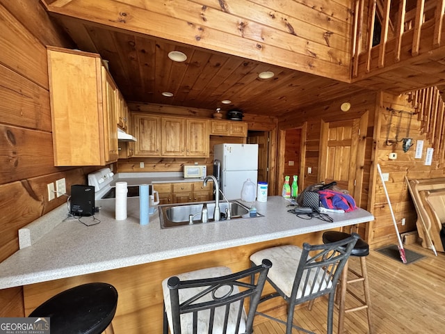 kitchen featuring wooden ceiling, a peninsula, white appliances, a sink, and light countertops