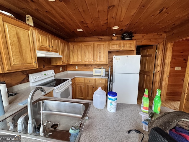 kitchen with white appliances, wood ceiling, light countertops, under cabinet range hood, and a sink