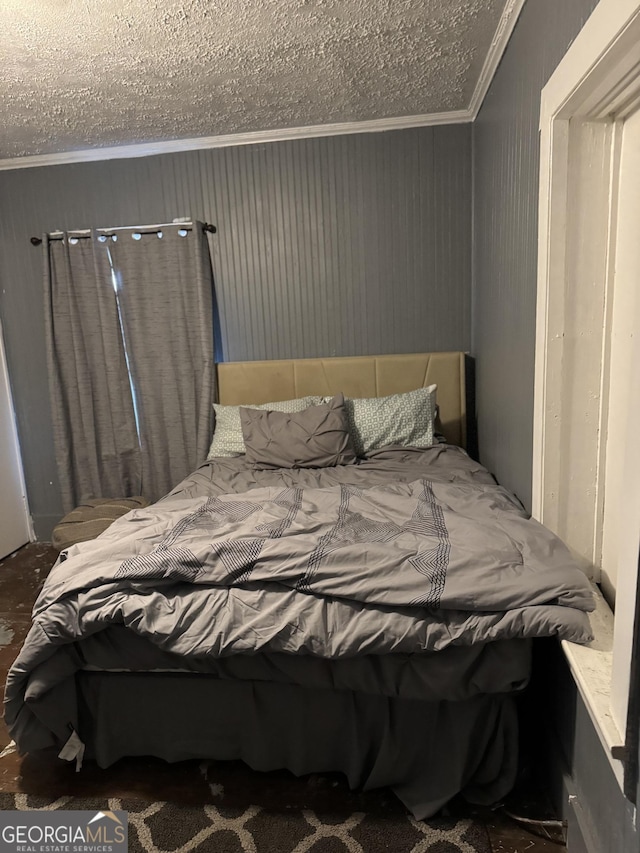 bedroom with a textured ceiling and crown molding