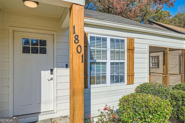 property entrance featuring roof with shingles