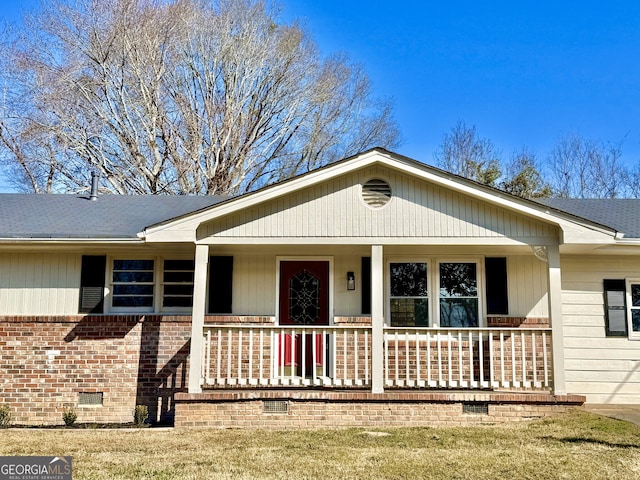 view of front of home with crawl space, a shingled roof, a porch, and brick siding