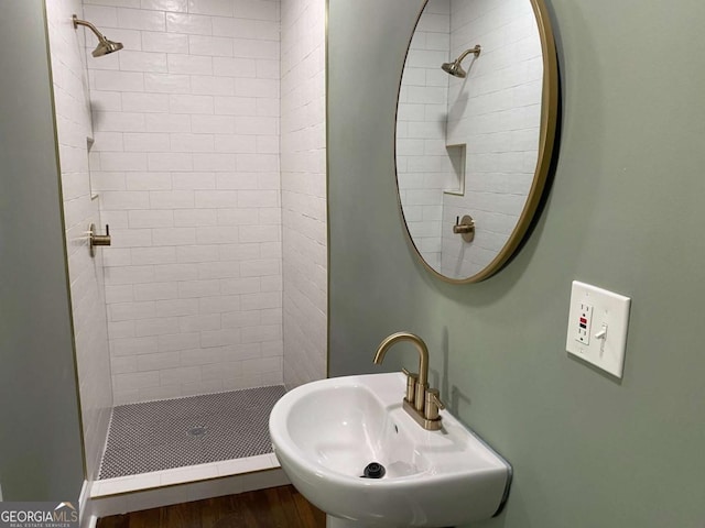 full bathroom with wood finished floors, a sink, and a shower stall