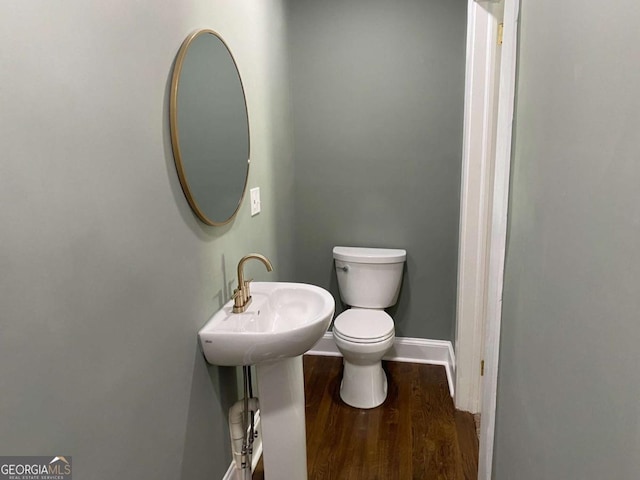 bathroom featuring wood finished floors, toilet, and baseboards