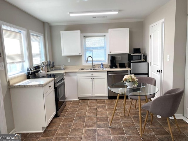 kitchen with stainless steel appliances, white cabinetry, and a sink