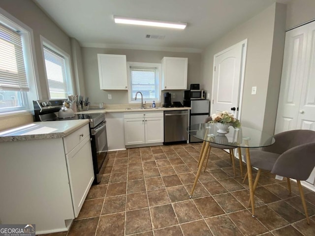 kitchen with stainless steel appliances, a sink, visible vents, and white cabinetry