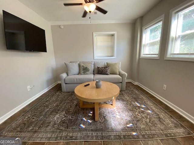 living room featuring a ceiling fan and baseboards