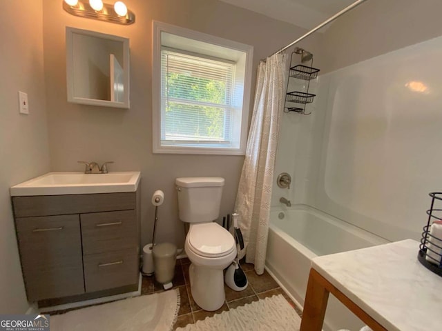 bathroom featuring toilet, vanity, shower / bath combo with shower curtain, and tile patterned floors