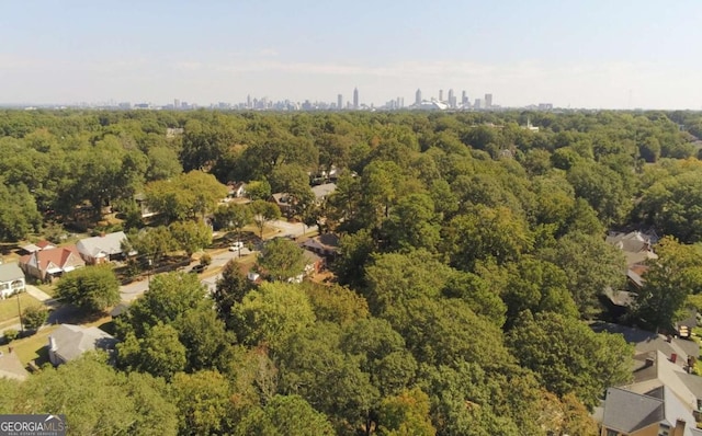 birds eye view of property with a view of city and a wooded view