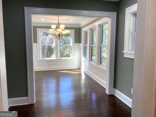 unfurnished dining area with baseboards, crown molding, a chandelier, and dark wood-type flooring