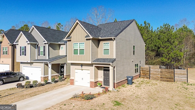 view of front facade with a garage, concrete driveway, fence, board and batten siding, and brick siding