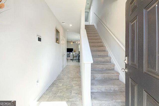 stairway featuring stone finish flooring and baseboards