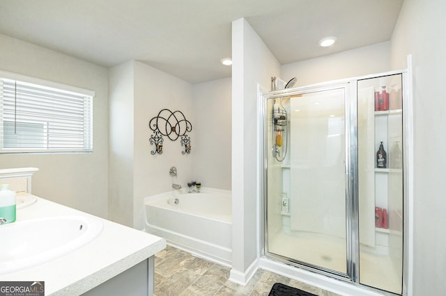 bathroom with a stall shower, a garden tub, and vanity